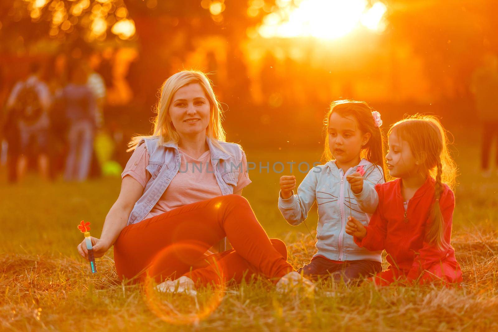 beautiful young mother and her daughter having fun at the field.