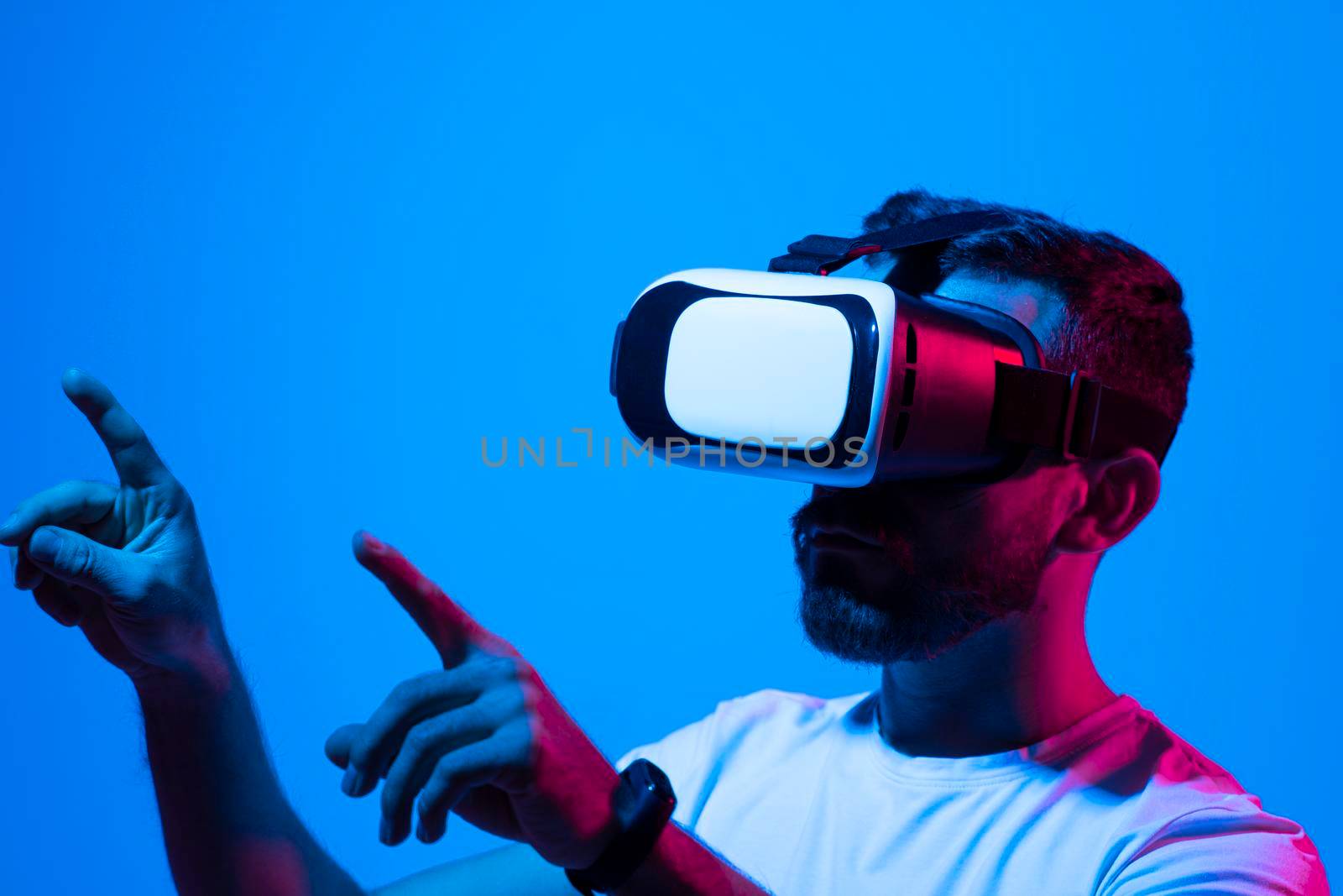 Man's portrait of bearded man wearing virtual reality glasses. Handsome caucasian male using VR headset, playing video games. Playing with VR