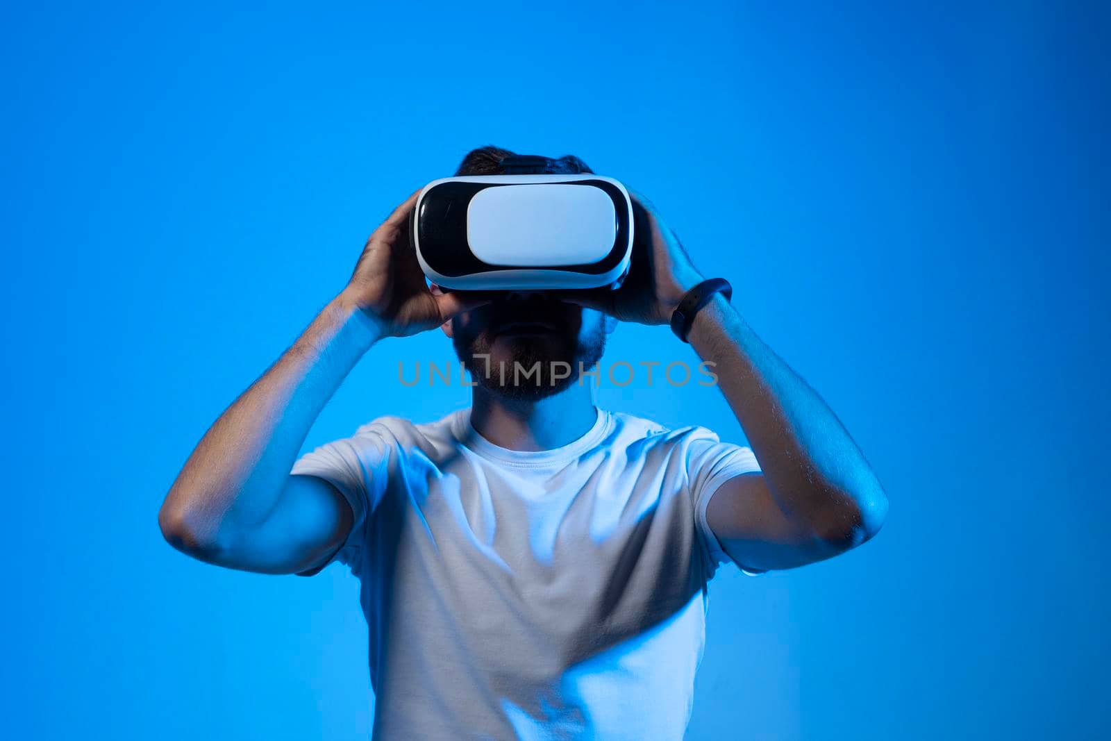 Closeup portrait of bearded man wearing VR goggles, working over virtual project, enjoying new reality, playing video game, posing isolated against violet wall. Technology, innovation gadgets. by vovsht