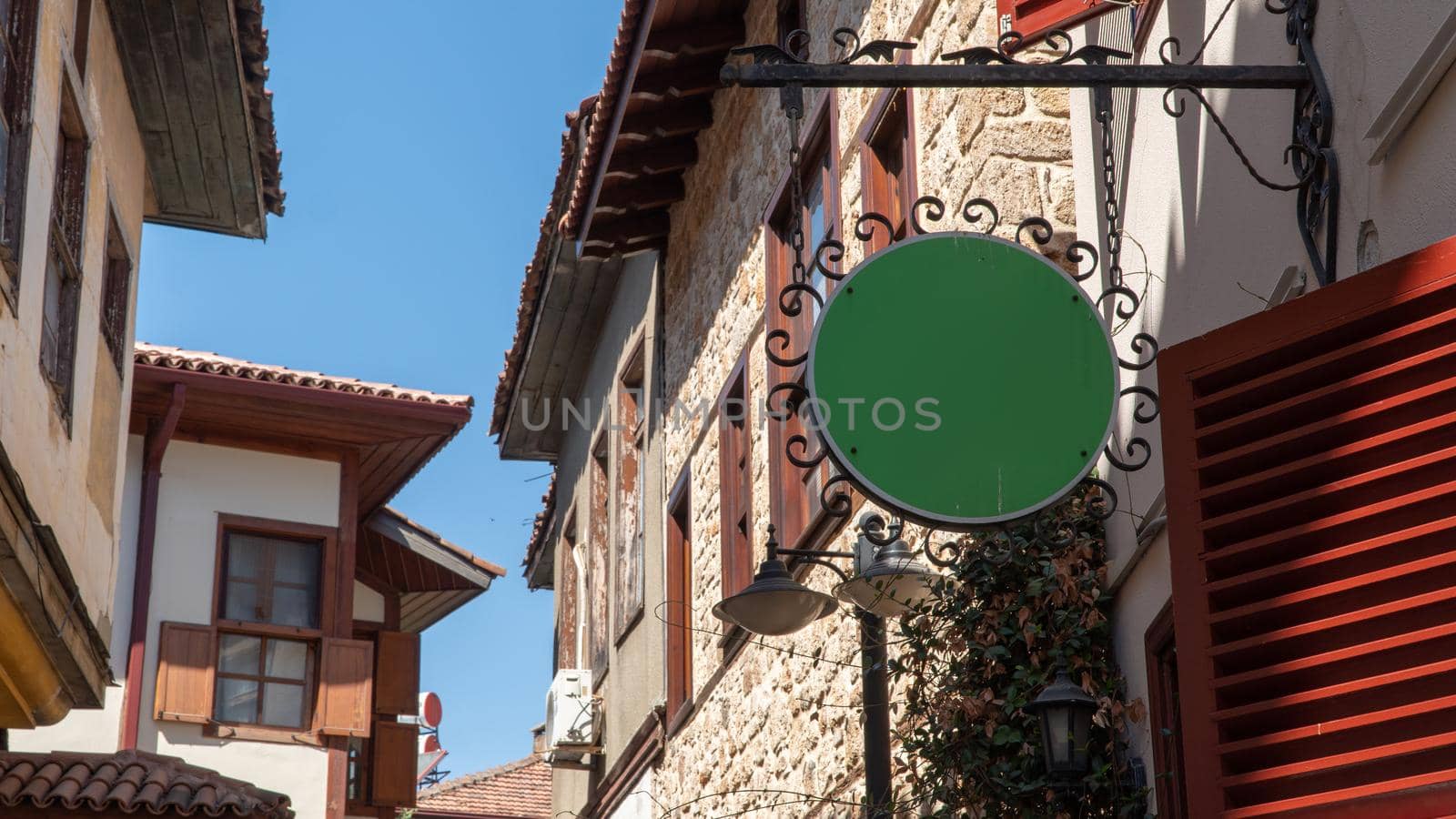 Round sign with space for text among old brick houses and tiles by voktybre