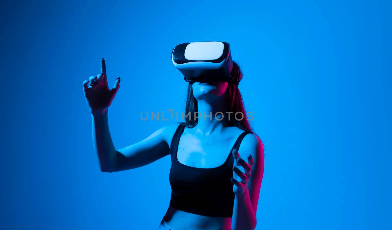 Creative engineer woman working with virtual reality. Young woman testing VR glasses or goggles in studio