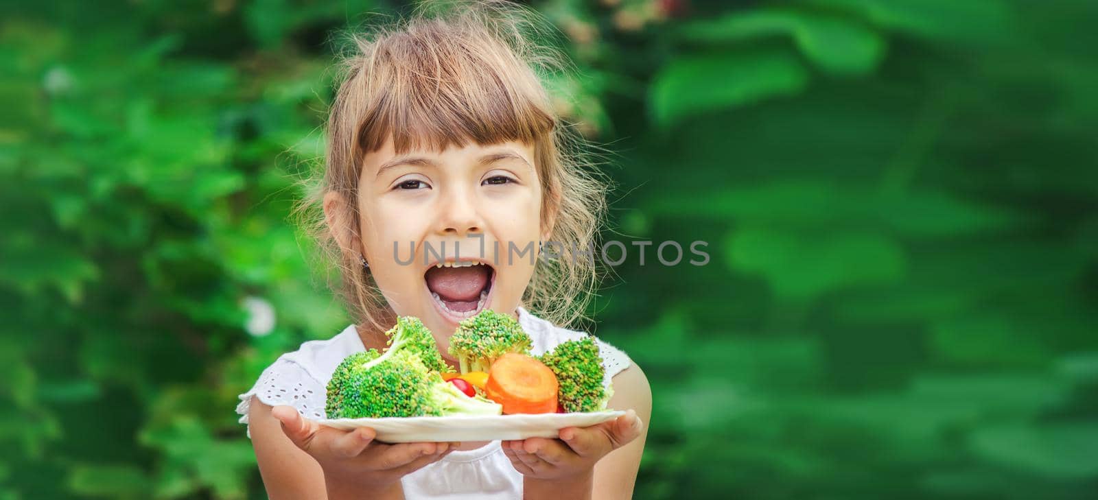 child eats vegetables. Summer photo. Selective focus nature