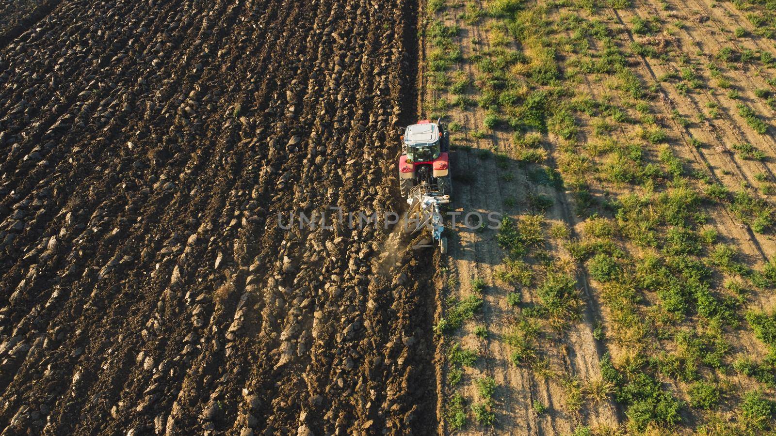 Aerial view with drone of tractor plowing the land in the countryside.