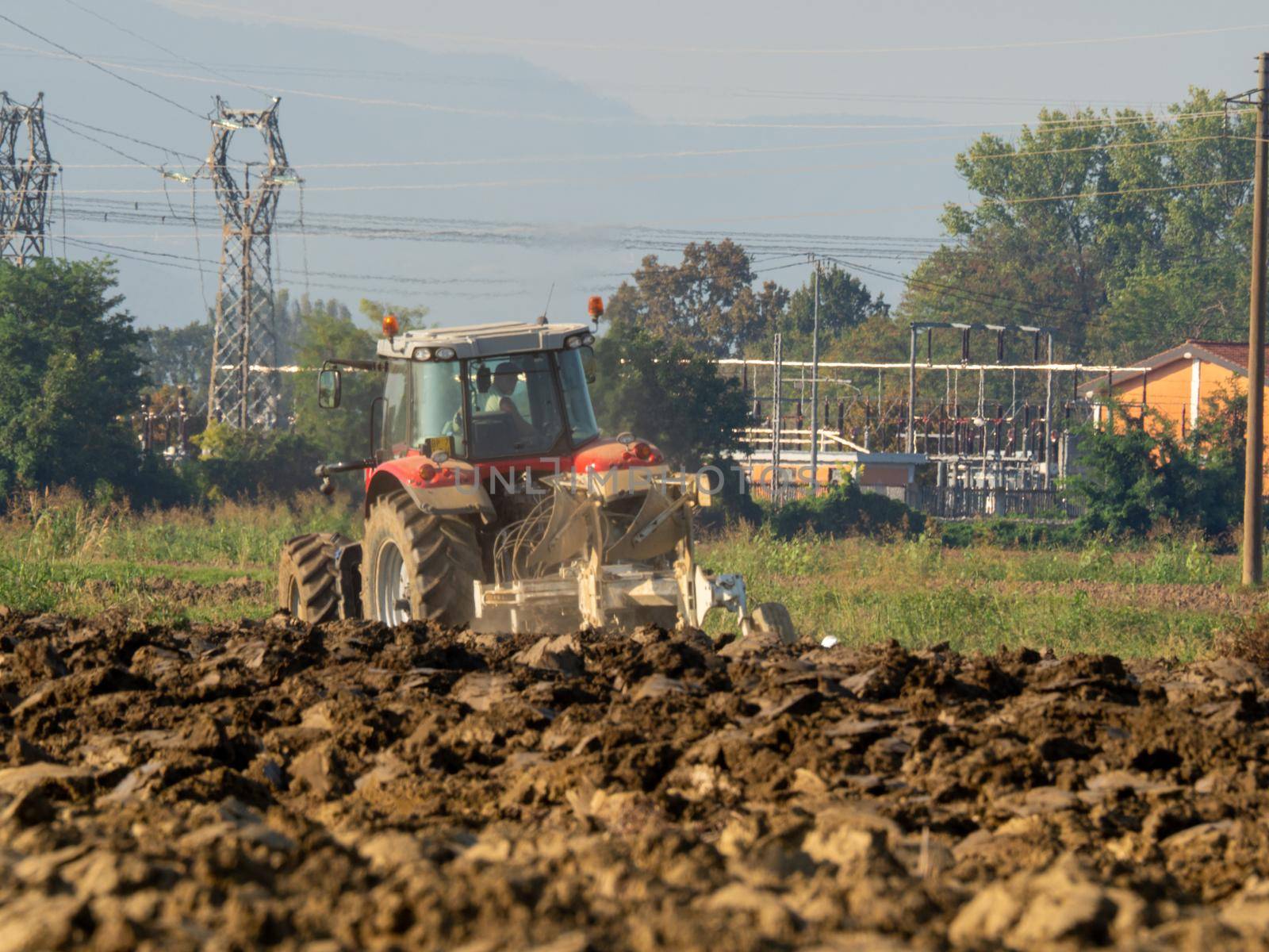 farmer with tractor plowing the land in the countryside.