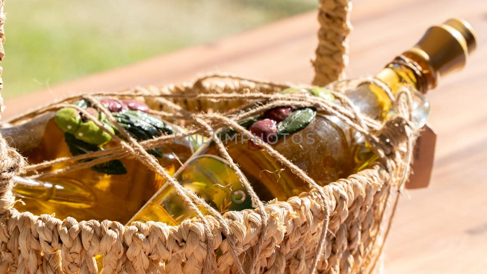 Olive oil in a glass bottle in a braided straw basket. High quality photo