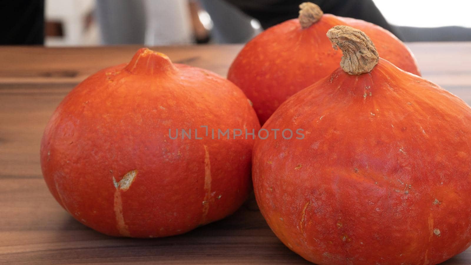 Three orange pumpkins on the table close-up by voktybre