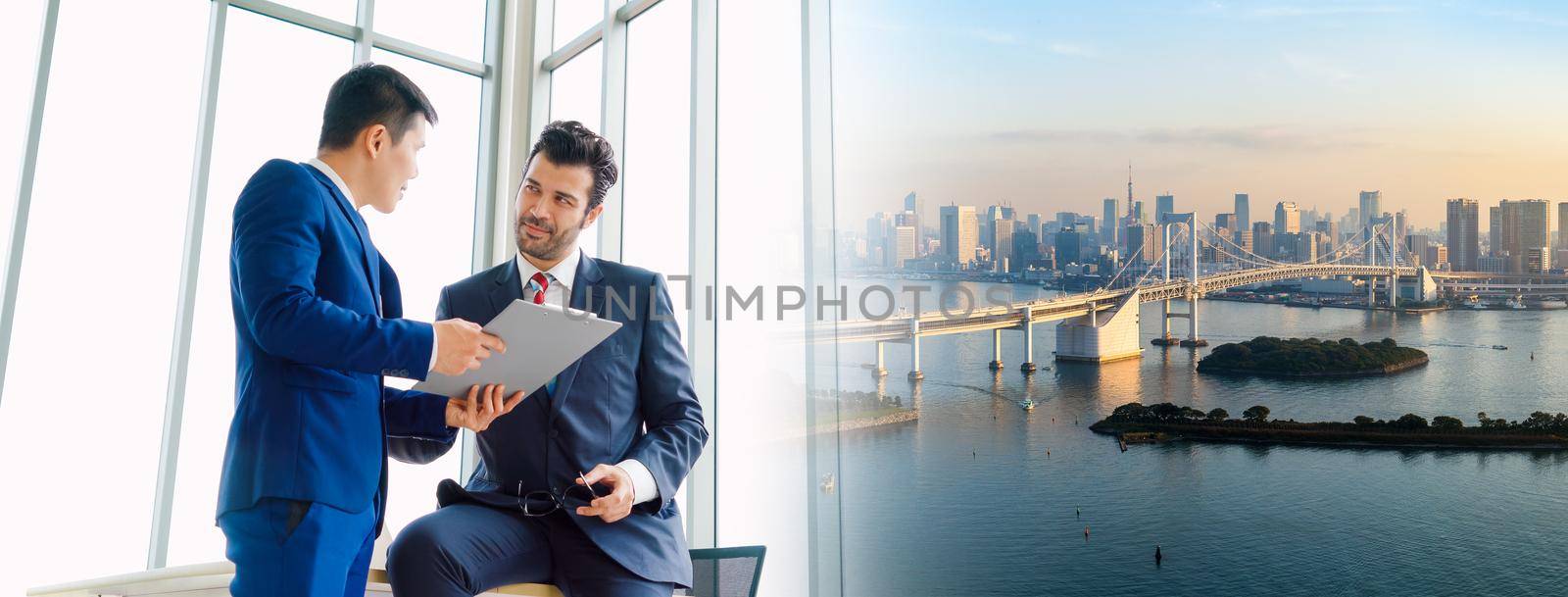 Two business people talk project strategy at office in widen view meeting room. Businessman discuss project planning with colleague at modern workplace .