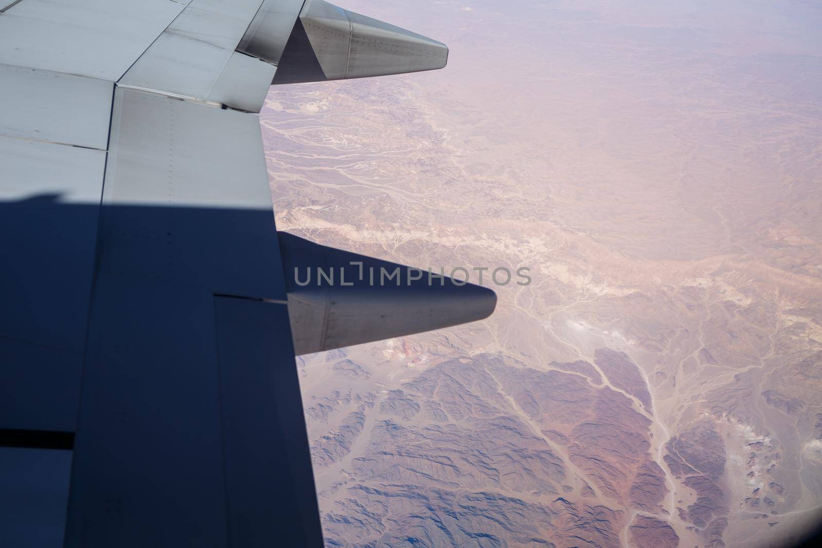Airplane wing in the air against a blue sky