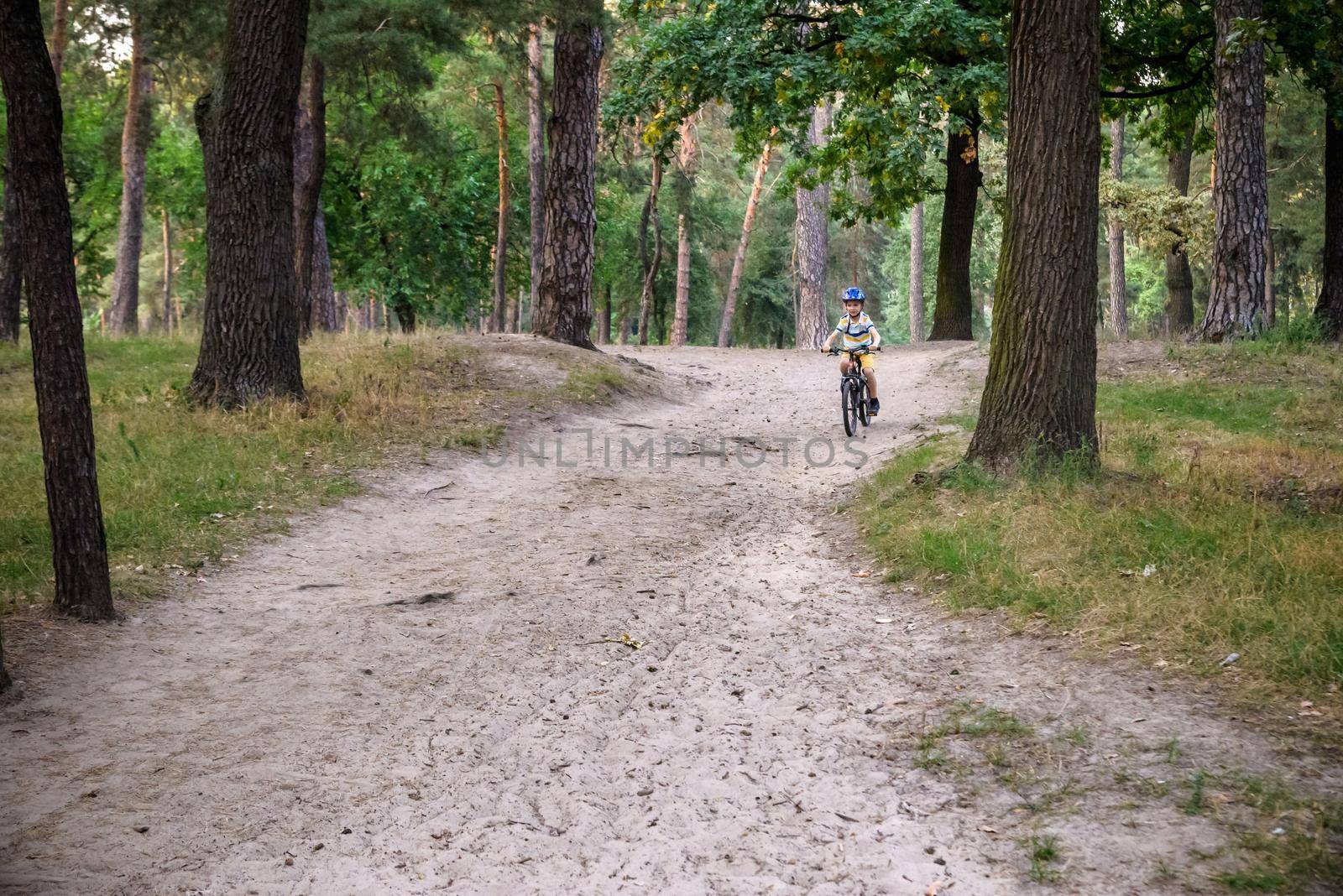 Cyclist Riding down the sandy Hill on the Offroad Trail.