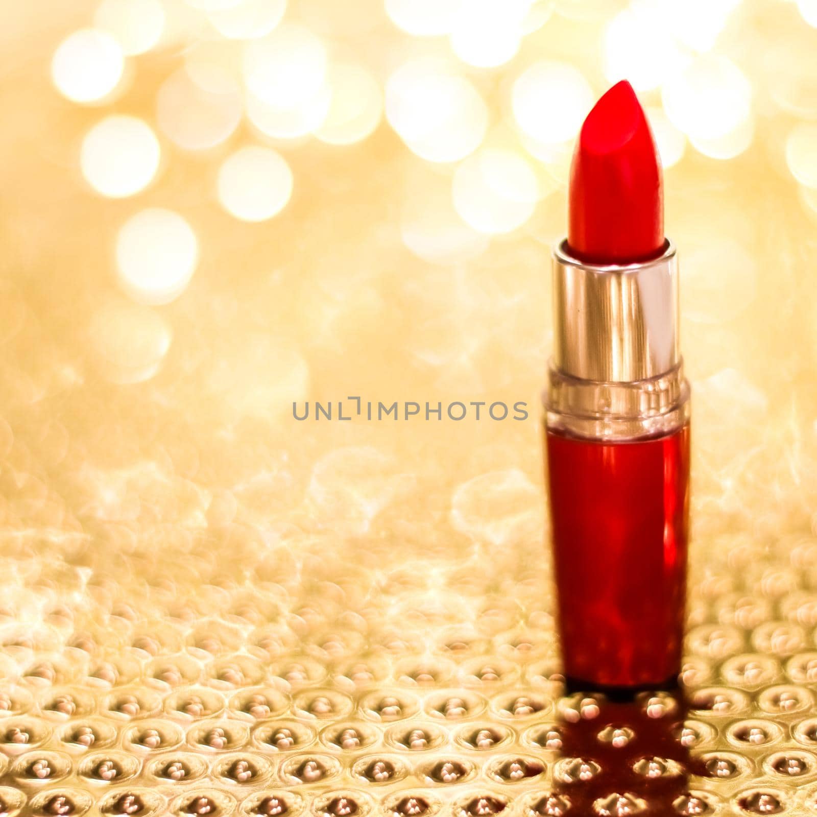 Cosmetic branding, sale and glamour concept - Red lipstick on golden Christmas, New Years and Valentines Day holiday glitter background, make-up and cosmetics product for luxury beauty brand