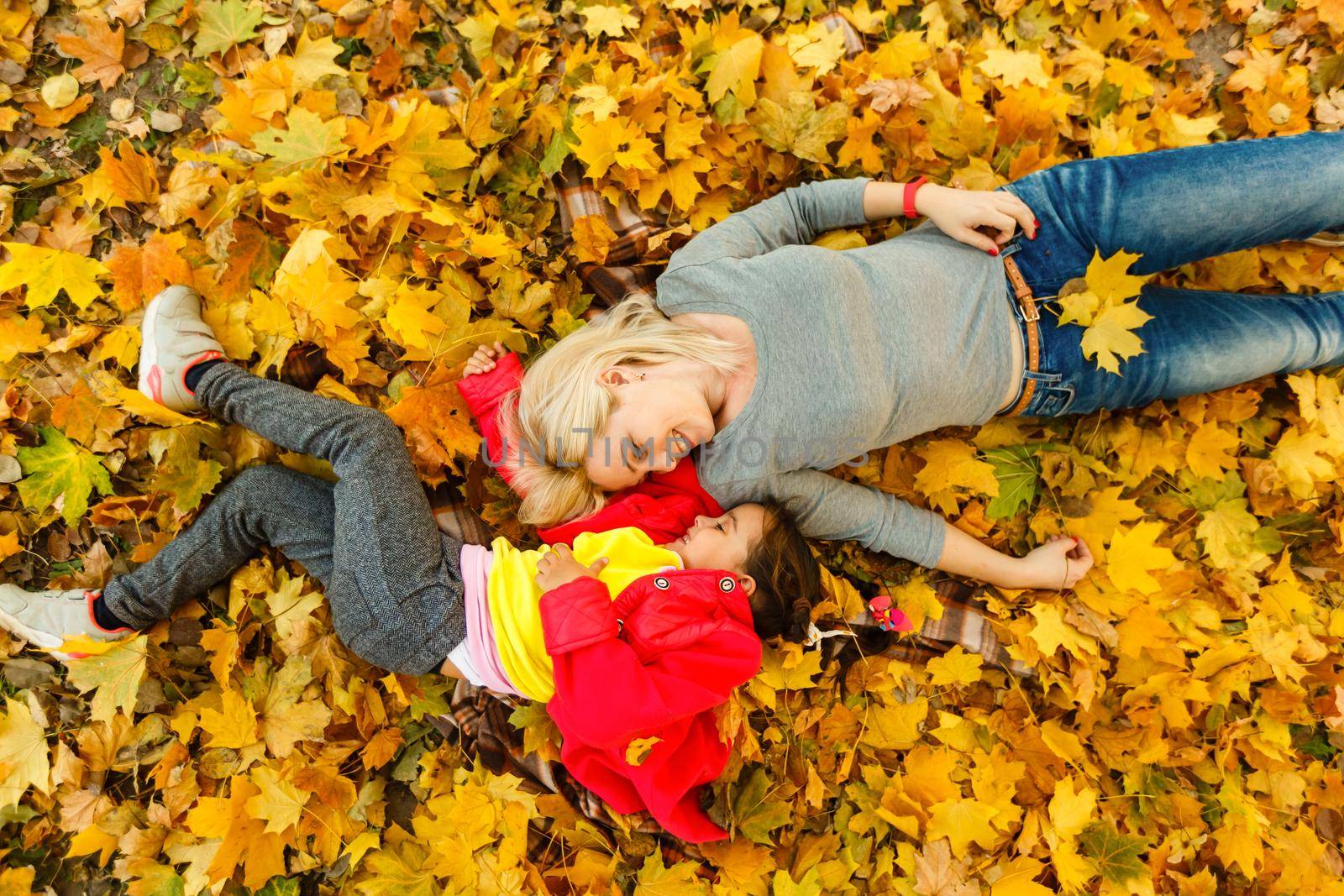 happy family mother and child daughter playing and laughing on autumn walk. by Andelov13