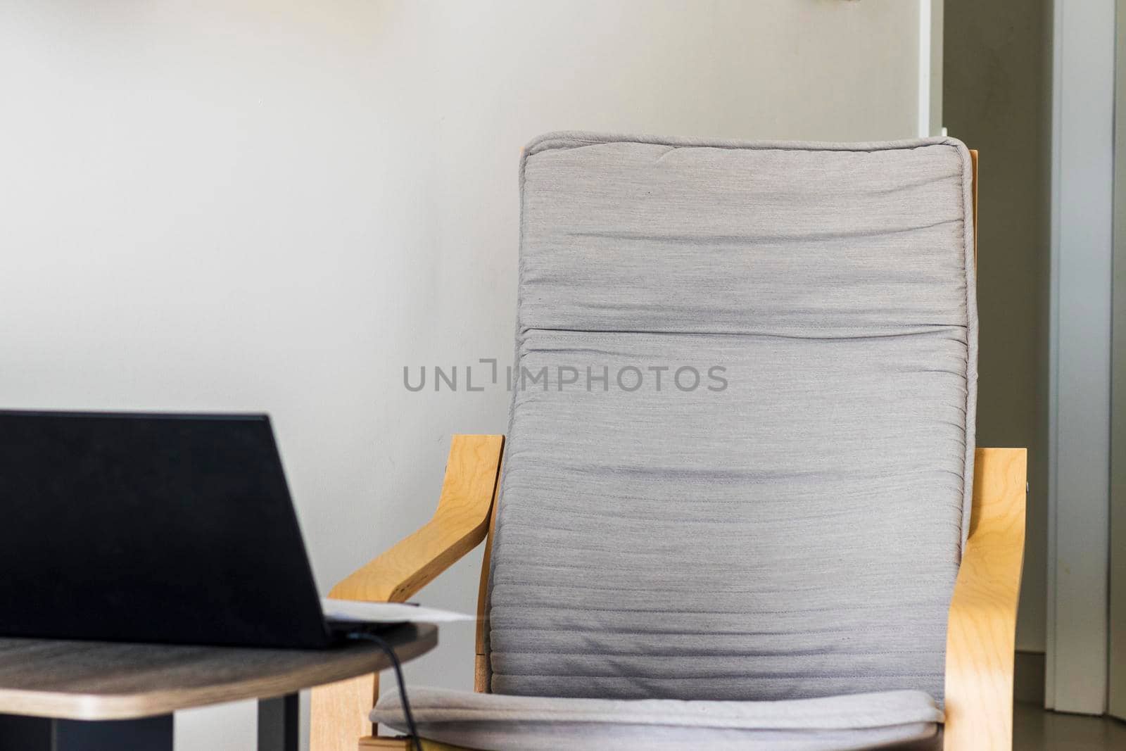 Shot of an arm chair, coffee table and laptop on it
