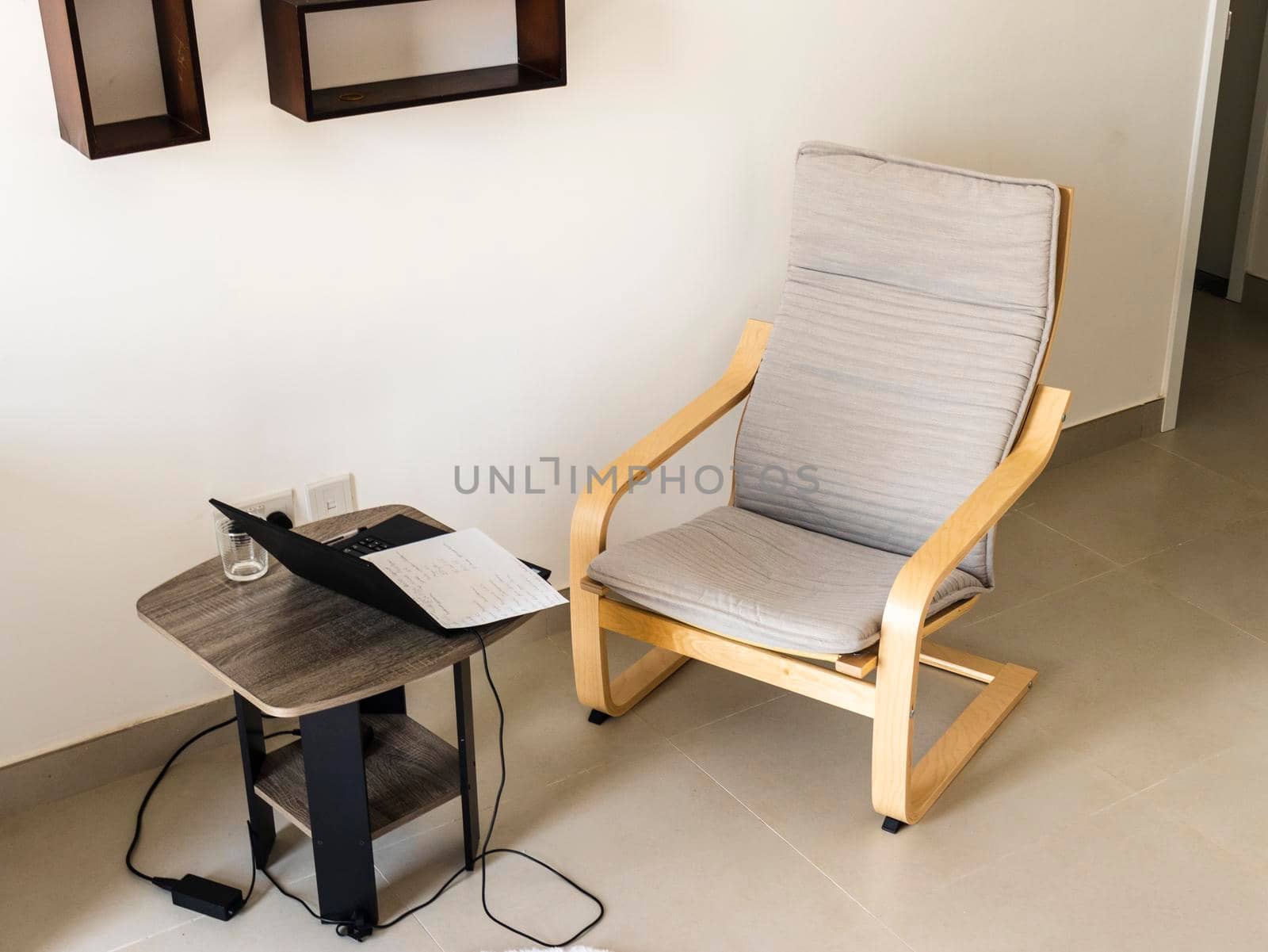 Shot of an arm chair, coffee table and laptop on it