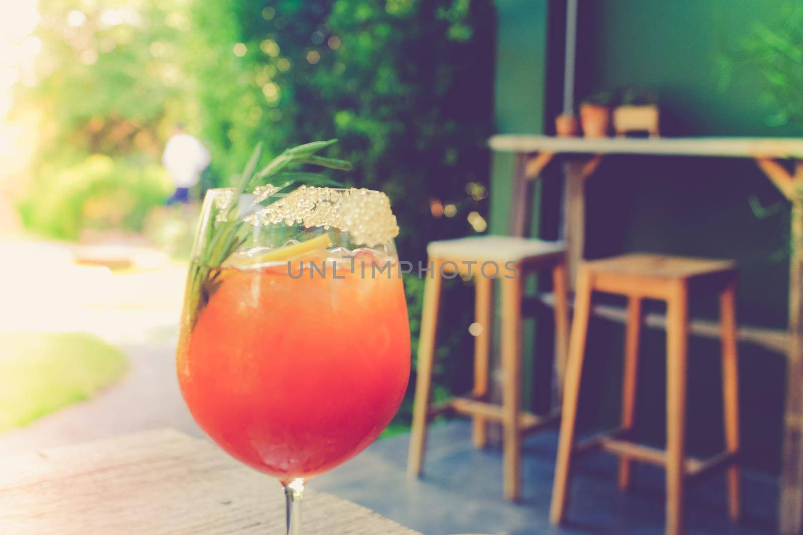 Fresh summer drink mocktail pour in glass on blur cafe bachground.
