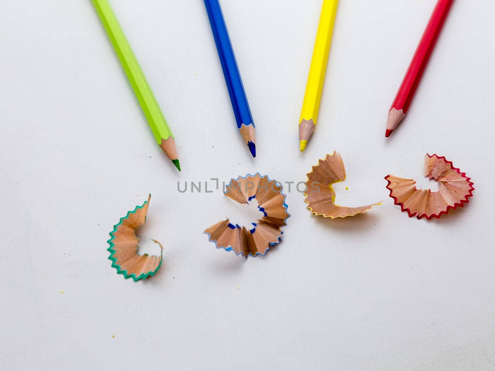 Colored pencil crayons in a row with shavings by imagesbykenny