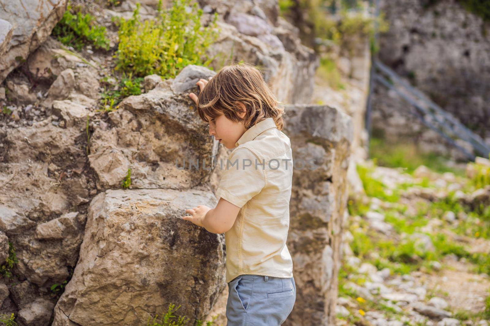 Boy tourist walks through the old town of Bar in Montenegro. Happy tourist walks in the mountains. Suburbs of the city of Bar, Montenegro, Balkans. Beautiful nature and landscape by galitskaya