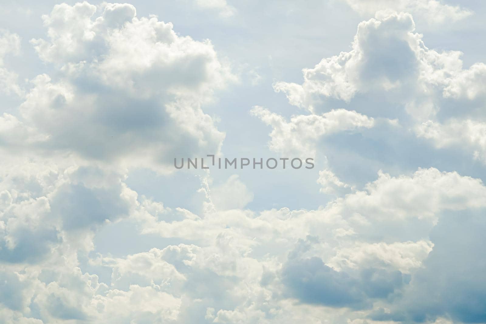 Abstract nature background with clouds in light tonality. White cumulus clouds