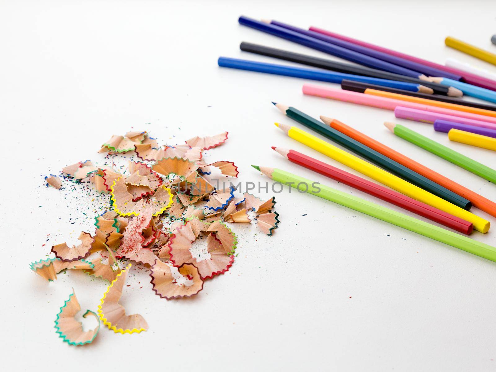 Colored pencil crayons in a row with shavings by imagesbykenny
