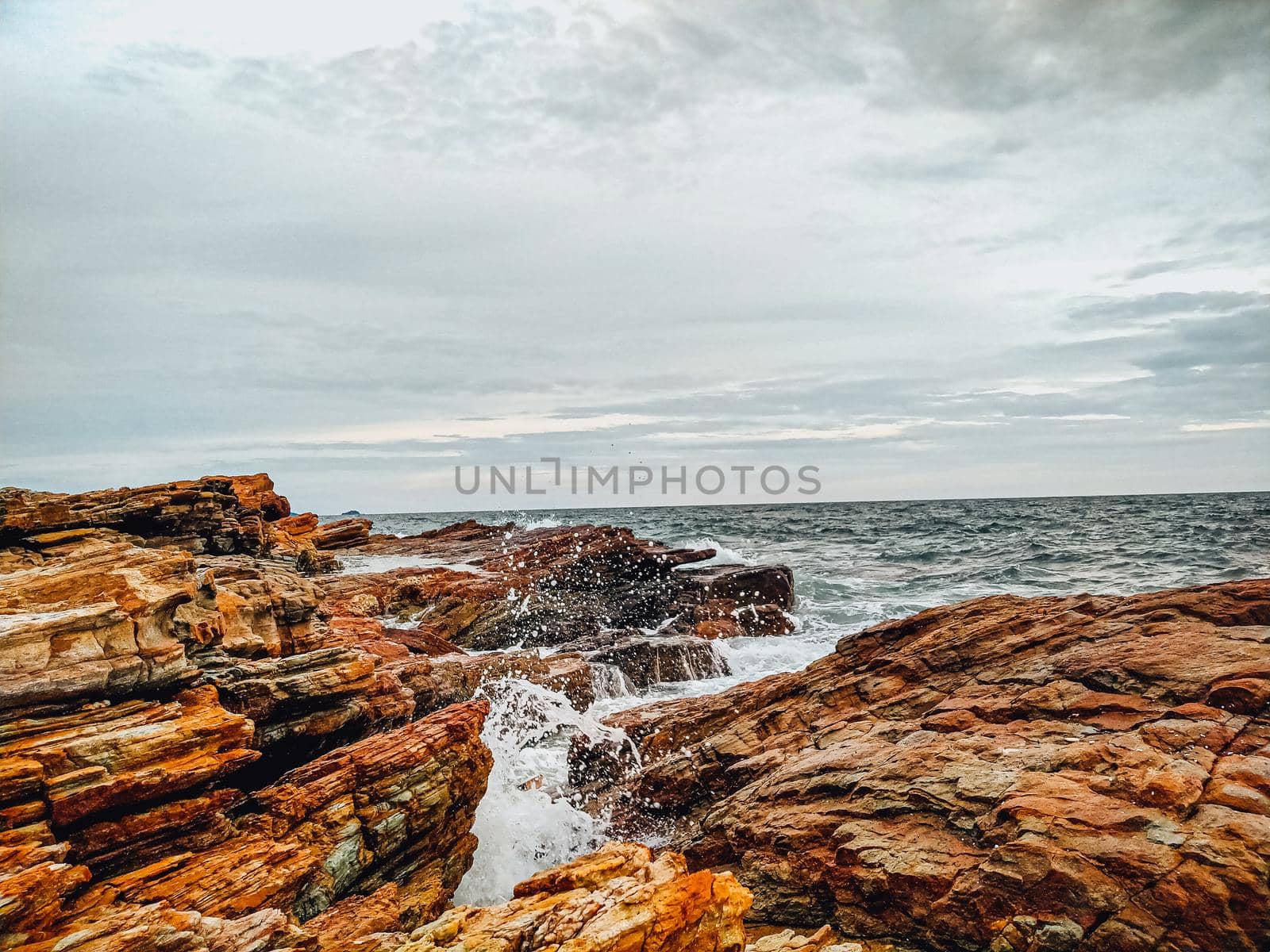 rocky coastline with ocean waves splashing on shore nature landscape background.