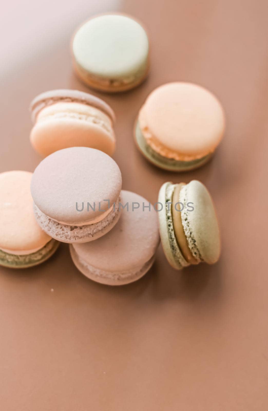 Pastry, bakery and branding concept - French macaroons on cream beige background, parisian chic cafe dessert, sweet food and cake macaron for luxury confectionery brand, holiday backdrop design