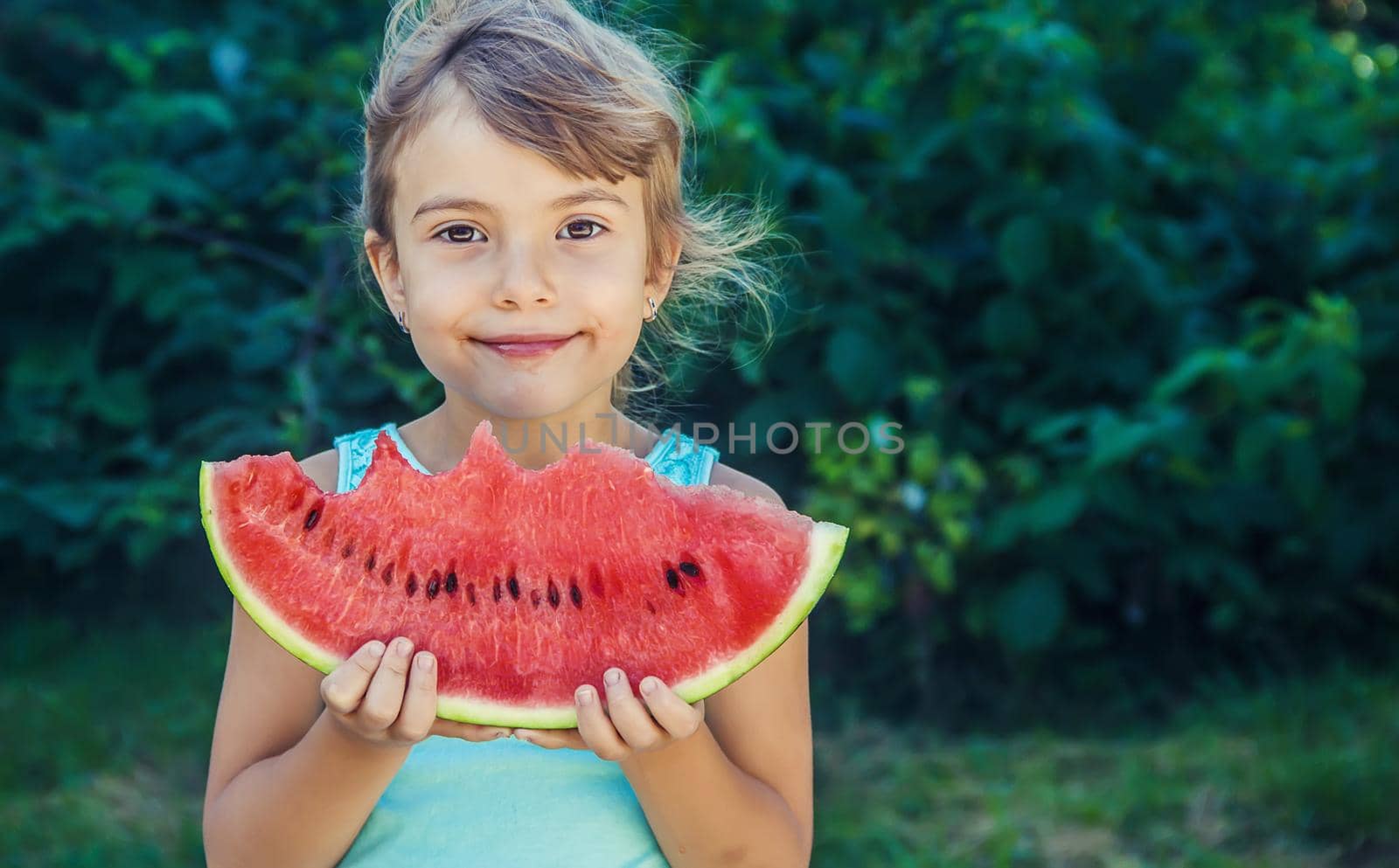 The child eats watermelon in summer. Selective focus. People.