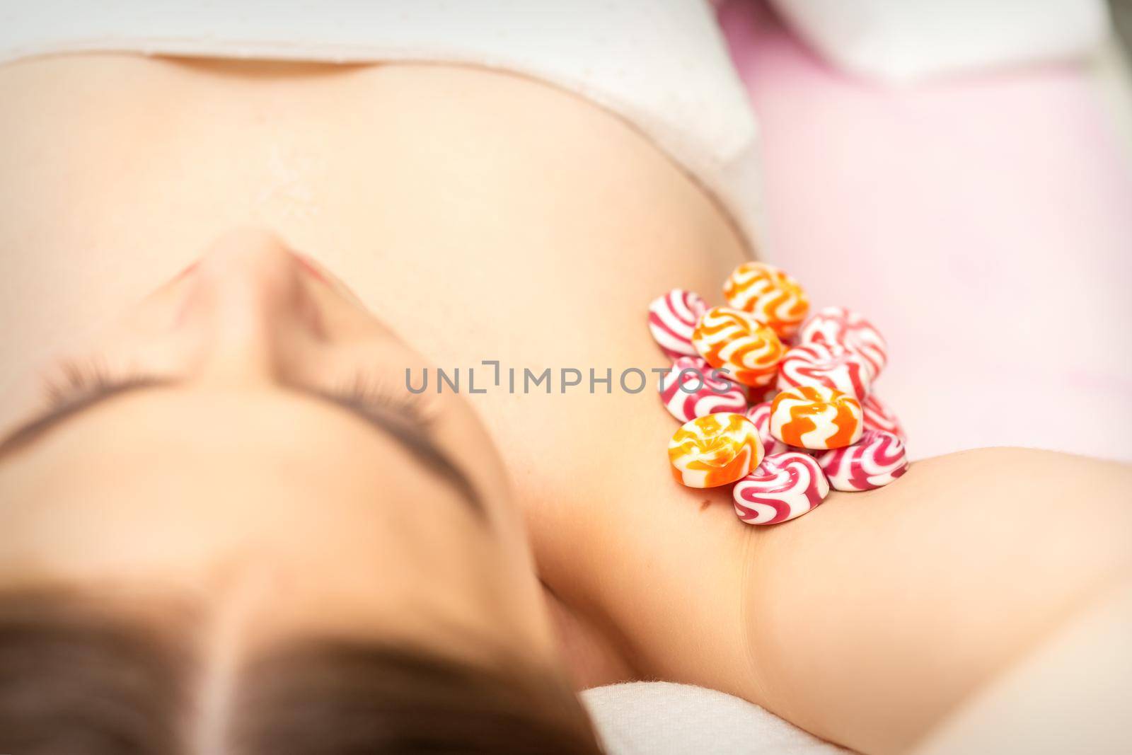 Waxing, depilation armpit concept. Colored round candies lying down on the female armpit, close up