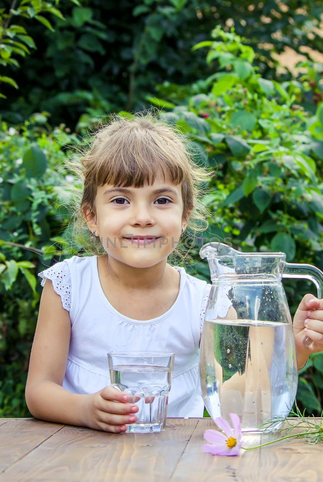 The child drinks clean water in summer. Selective focus. by yanadjana