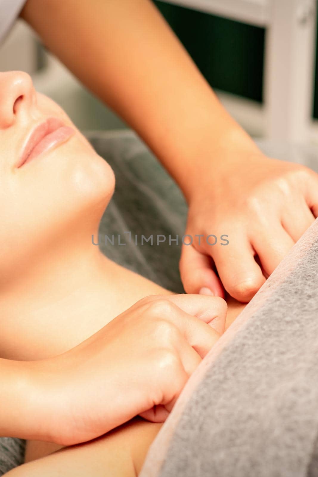 Massaging female breast, and shoulder. Young beautiful caucasian woman receiving chest and shoulders massage in beauty spa salon. by okskukuruza