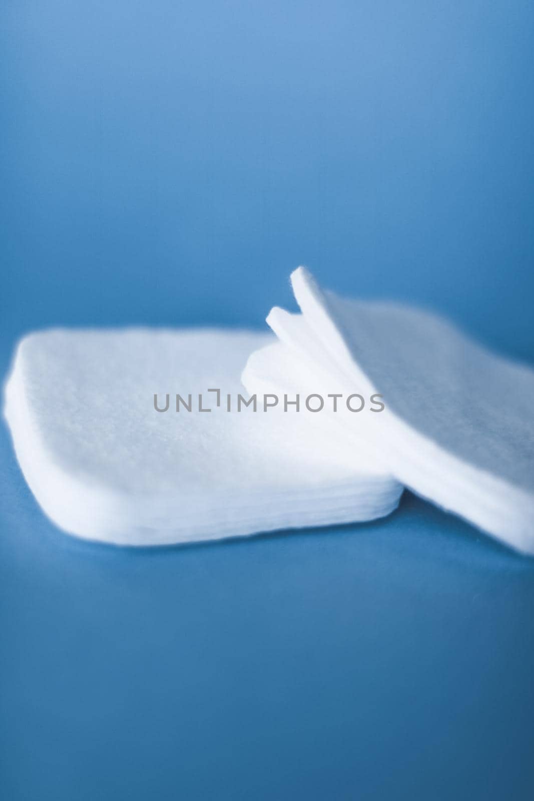 Cosmetology, cleanliness and branding concept - Organic cotton pads on blue background, cosmetics and make-up remover, hygiene and skincare beauty brand product for healthcare and medical design