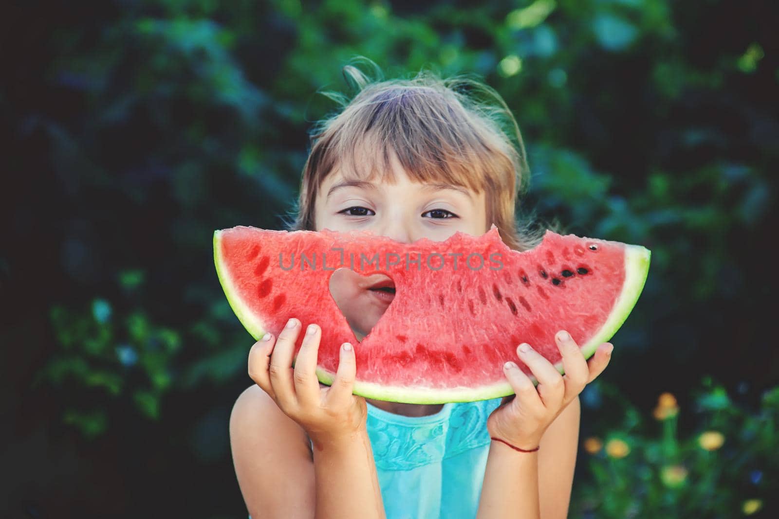 The child eats watermelon in summer. Selective focus. People.