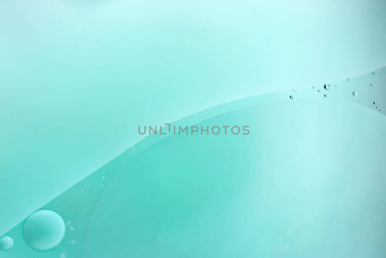 Oil drops in water. Defocused abstract psychedelic pattern image light blue colored. DOF.