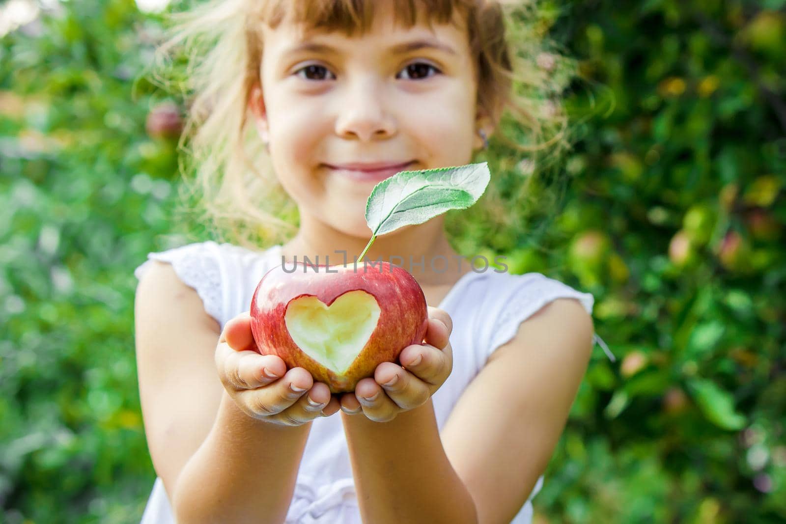 Child with an apple. Selective focus. Garden Food