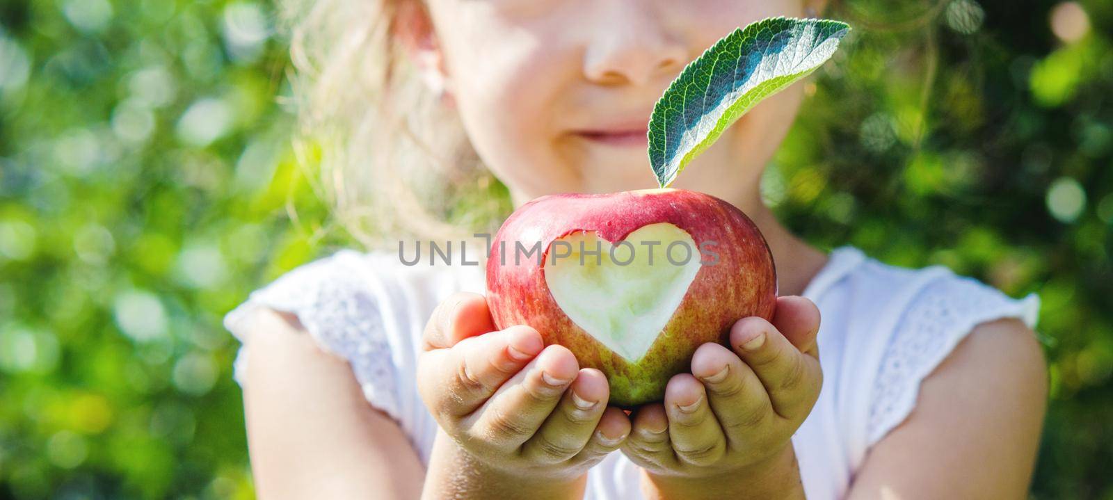 Child with an apple. Selective focus. Garden Food