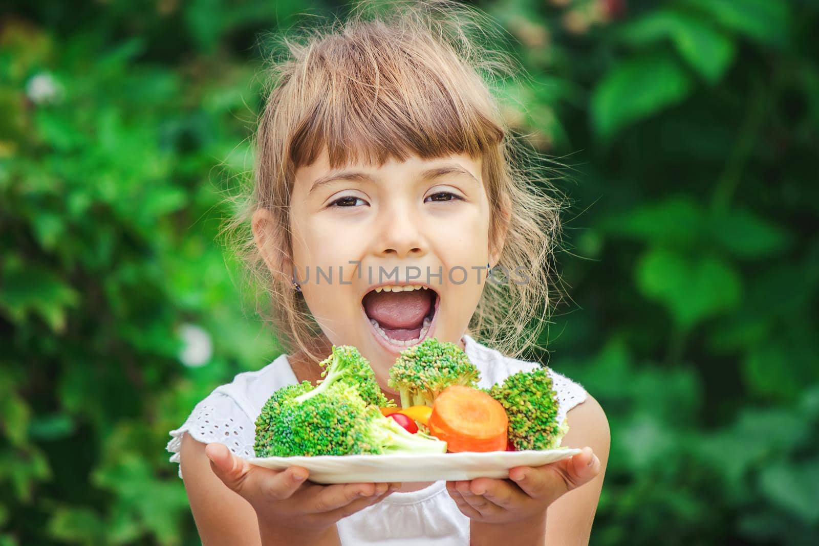 child eats vegetables. Summer photo. Selective focus nature