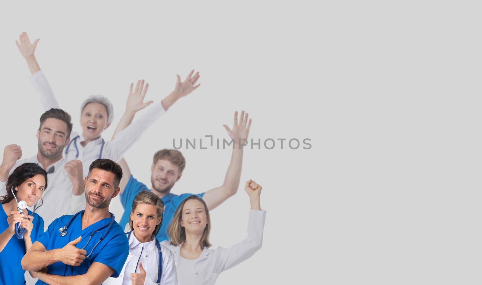 Group of happy smiling doctors raising their arms on gray background with copy space for text