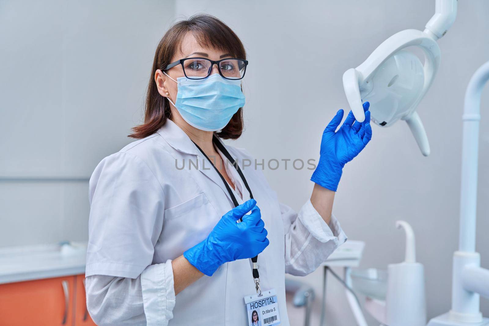 Serious confident female doctor dentist in face mask in dental office, looking at the camera. Dentistry, medicine, specialist, career, dental health care