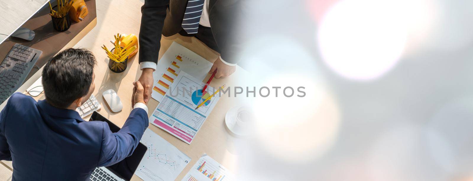 Group business people handshake at meeting table in widen view in office together with confident shot from top view . Young businessman and businesswoman workers express agreement of investment deal.