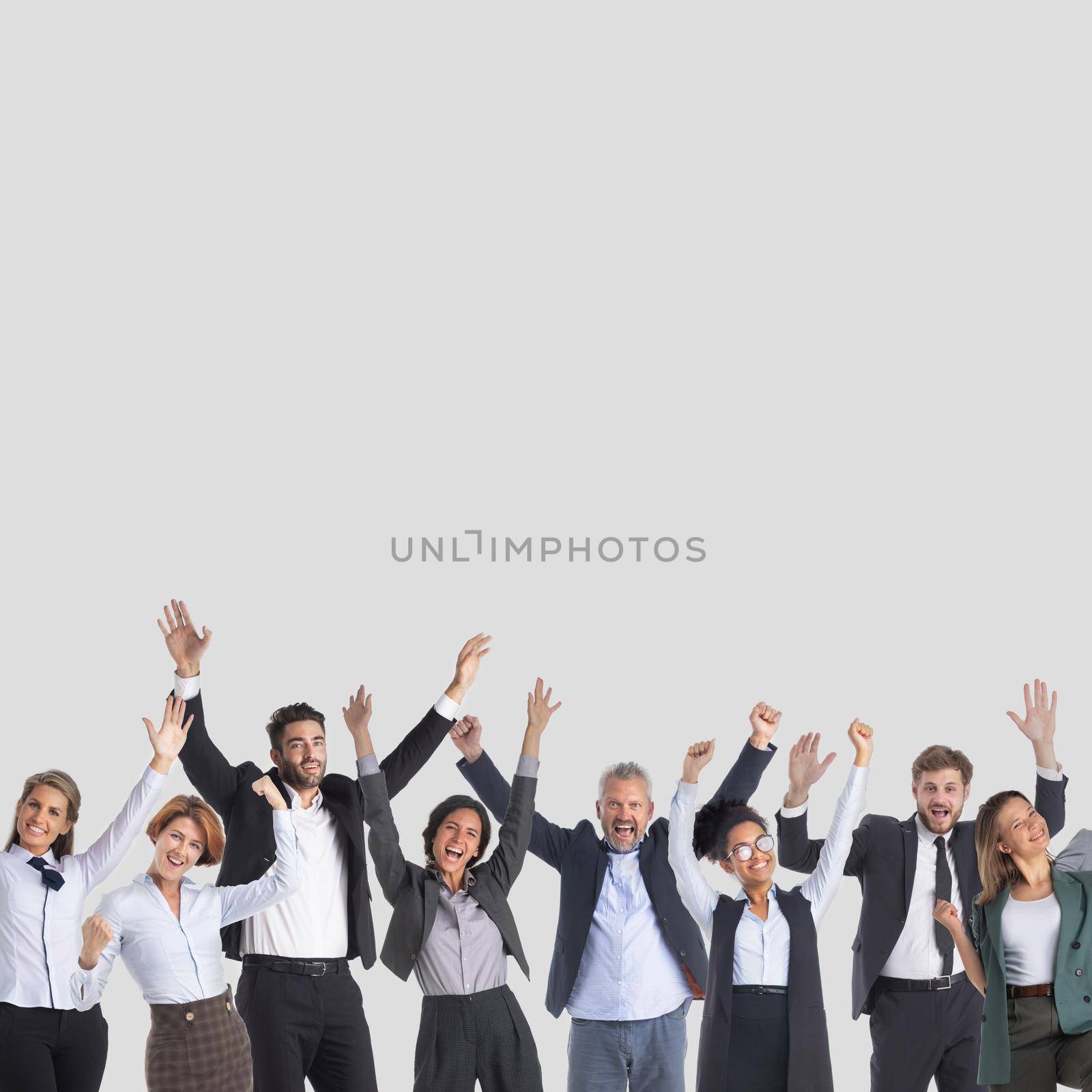 Happy group of business people raising arms over gray background, copy space for text content