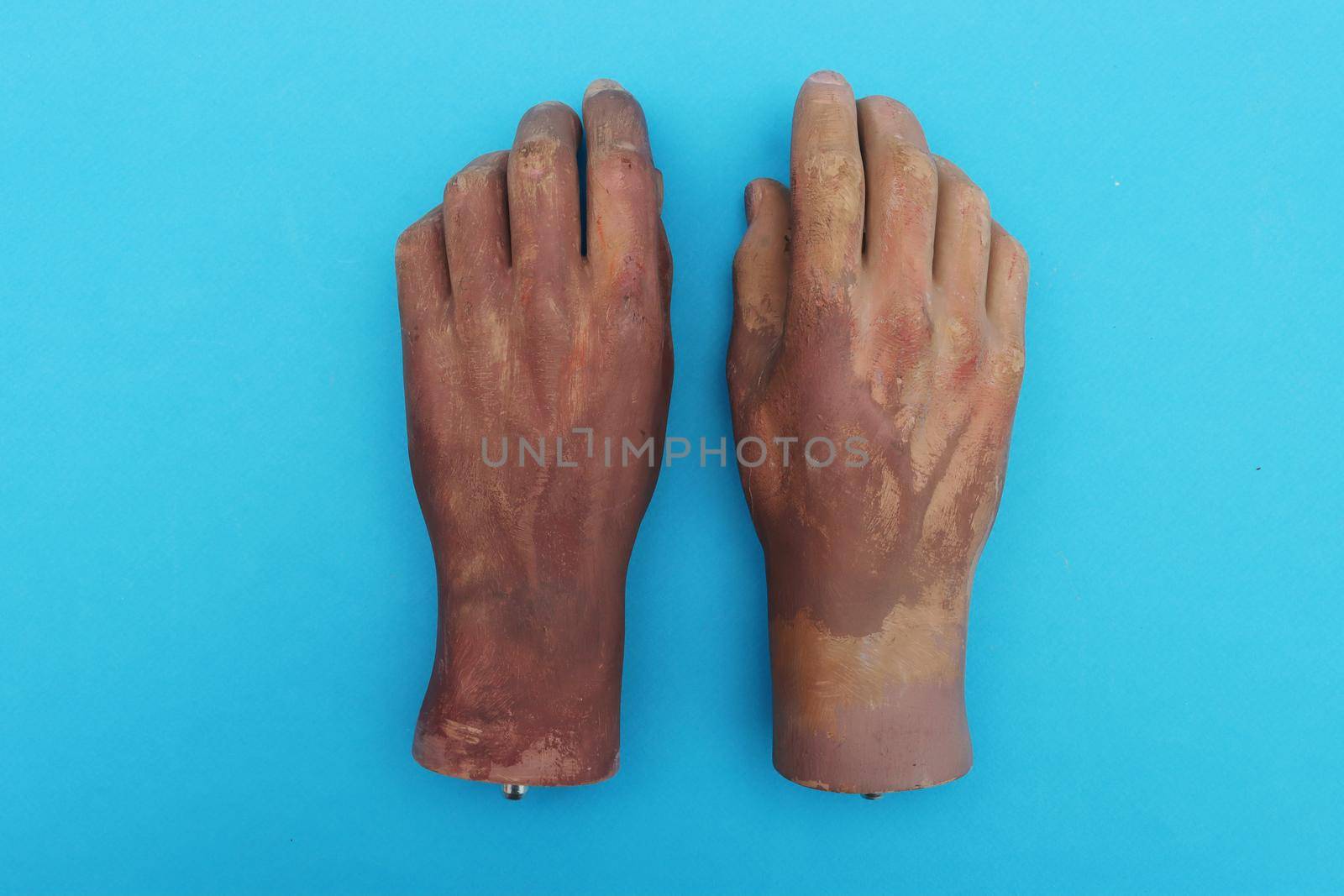 Artificial hands on blue paper background.