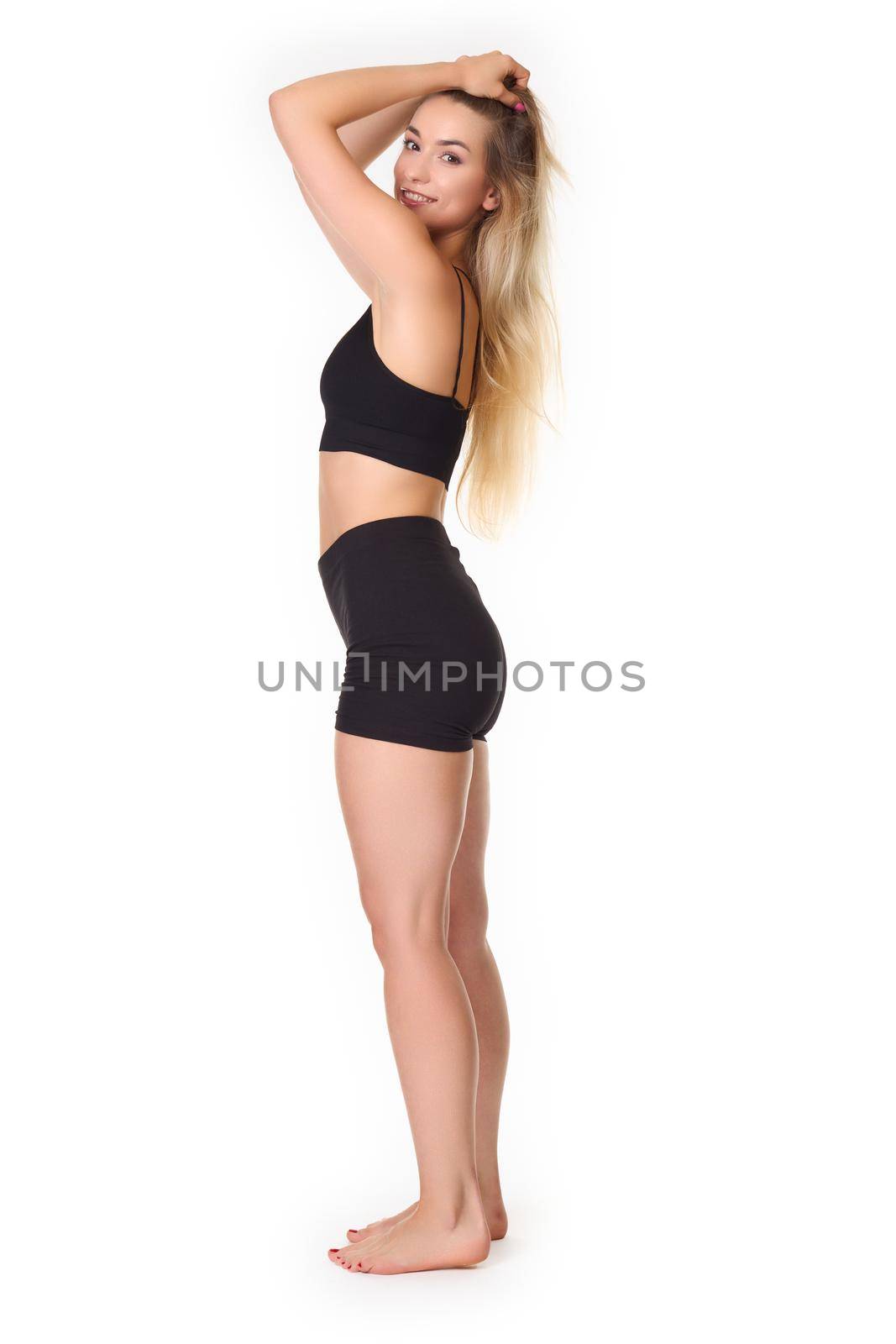 A young woman posing in a sports outfit on a white background. High quality photo