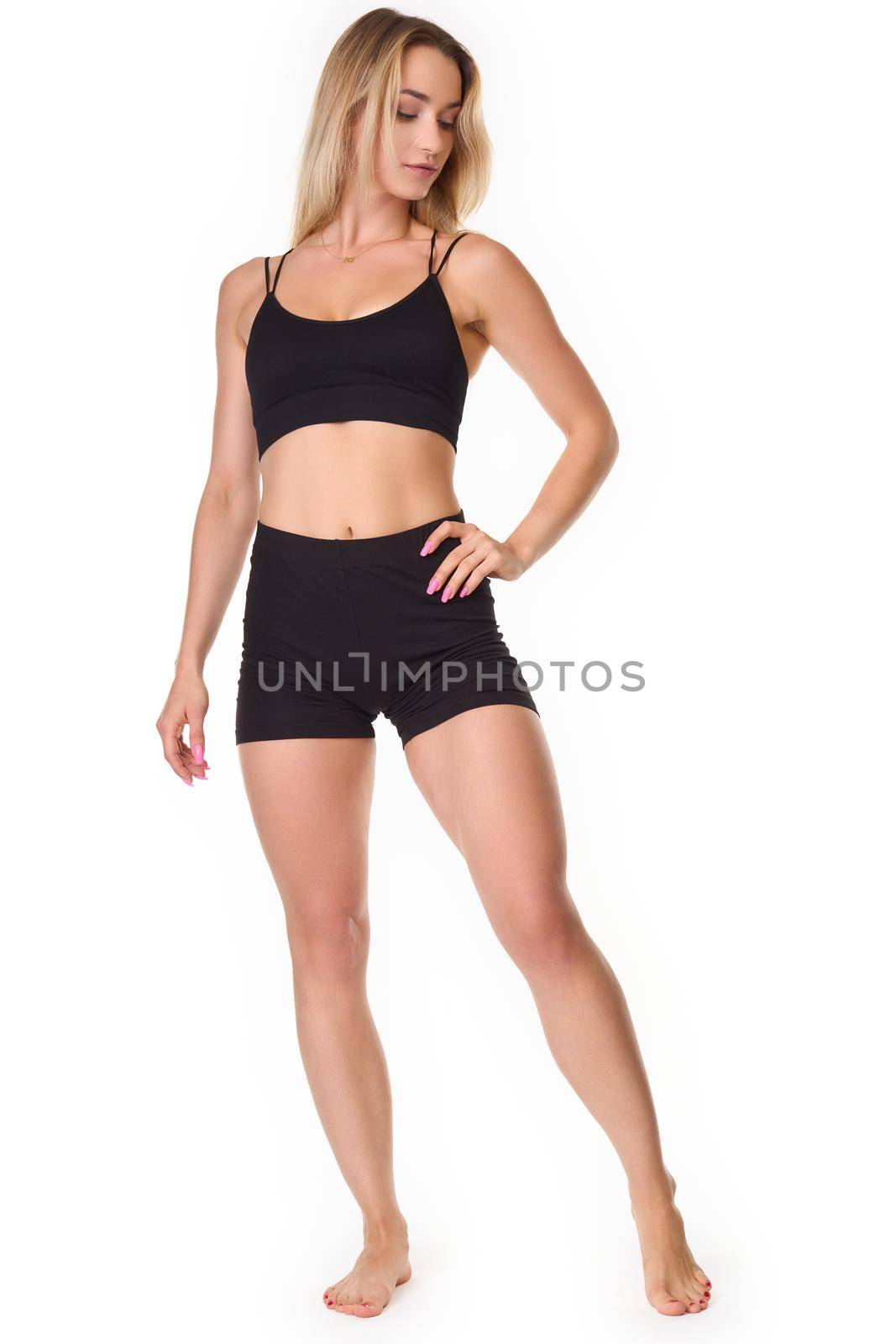 A young woman posing in a sports outfit on a white background by Jarosz