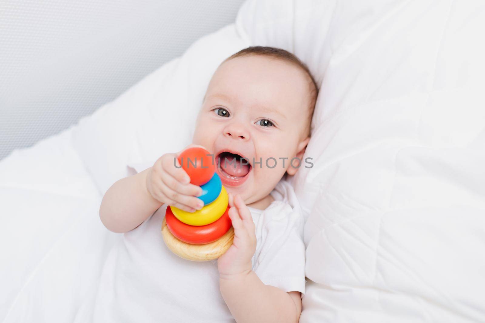 A kid with a wooden pyramid . Happy baby. Children's toys. by alenka2194