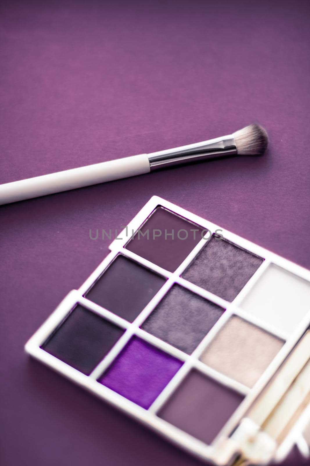 Cosmetic branding, mua and girly concept - Eyeshadow palette and make-up brush on purple background, eye shadows cosmetics product as luxury beauty brand promotion and holiday fashion blog design