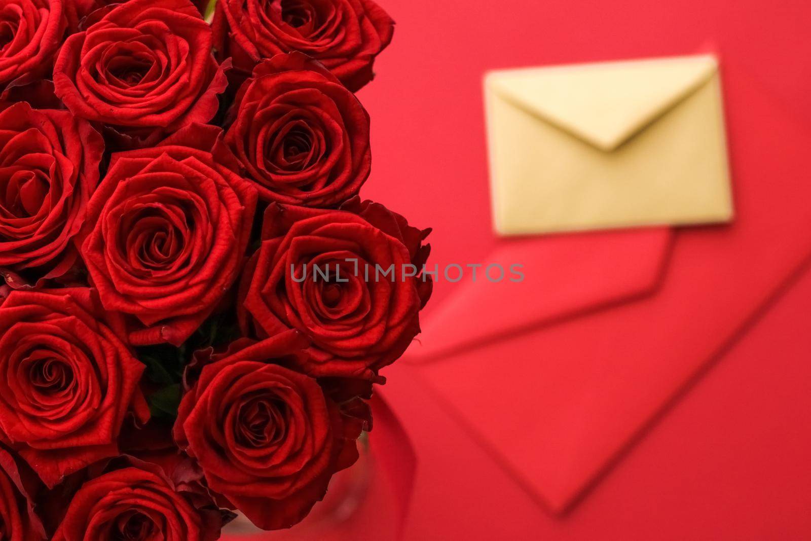 Holiday gift, flowers flatlay and happy relationship concept - Love letter and flower delivery service on Valentines Day, luxury bouquet of red roses and card envelopes on red background