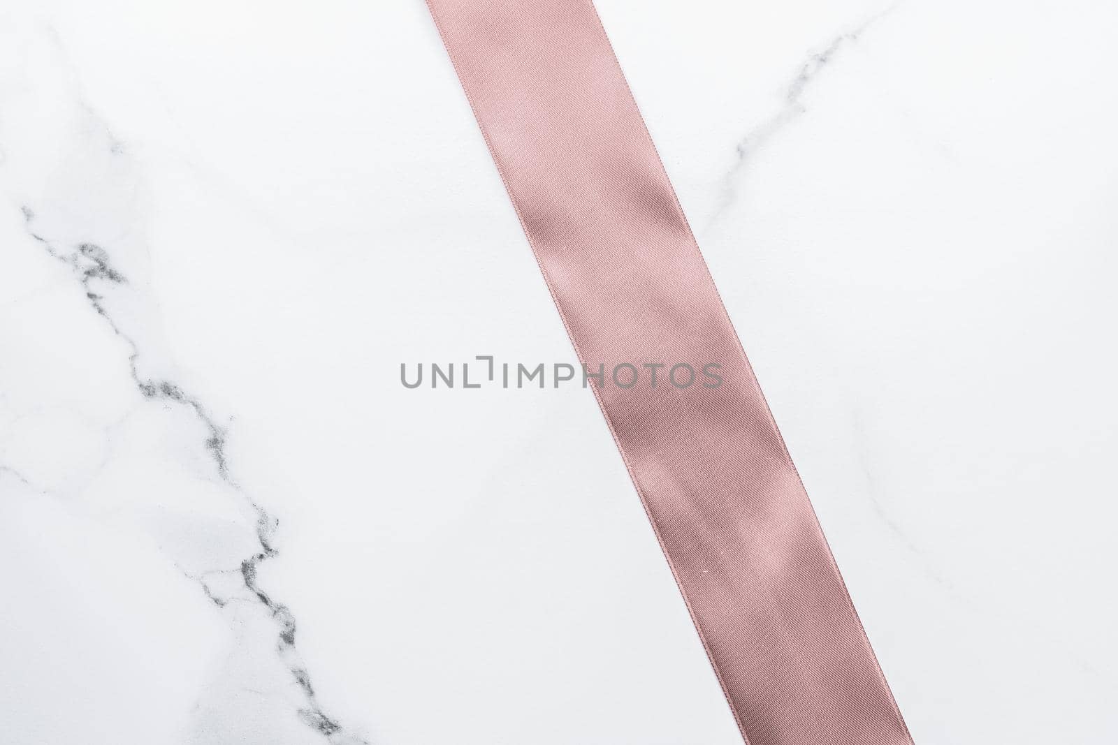 Birthday, wedding and girly branding concept - Beige silk ribbon and bow on marble background, glamour present mockup and fashion gift decoration for luxury beauty brand holiday flatlay design