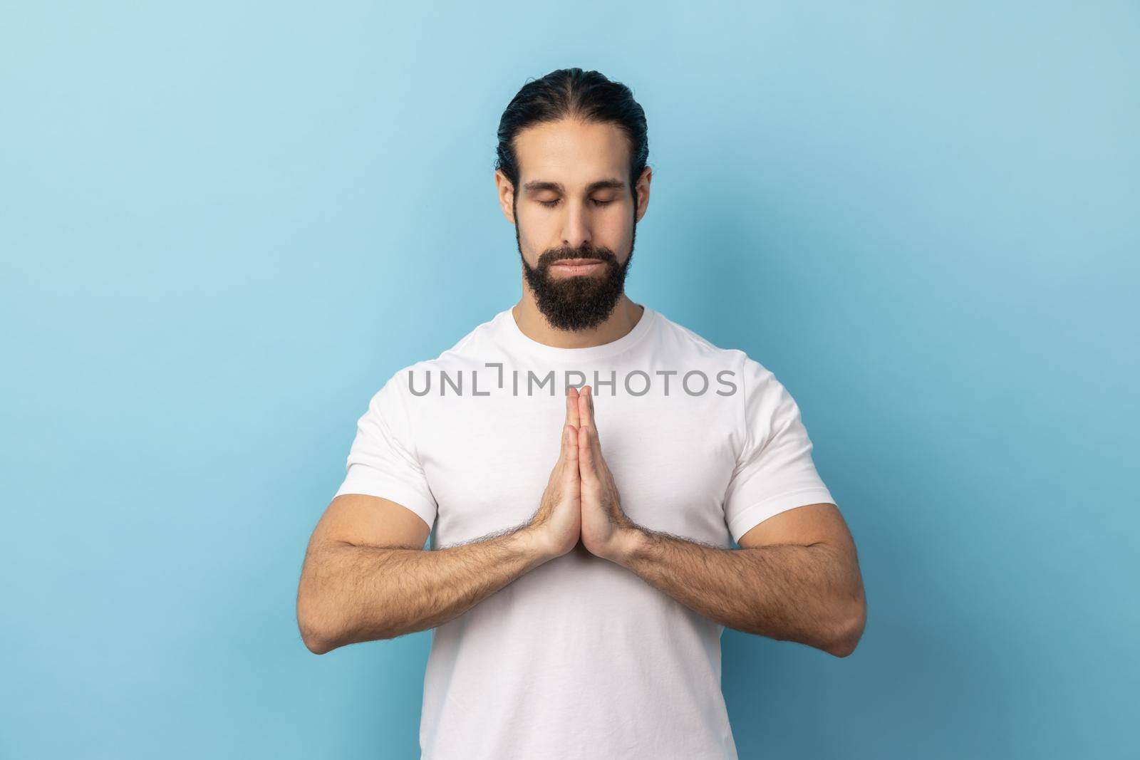 Man concentrating his mind, keeping hands namaste gesture meditating, yoga exercise breath technique by Khosro1