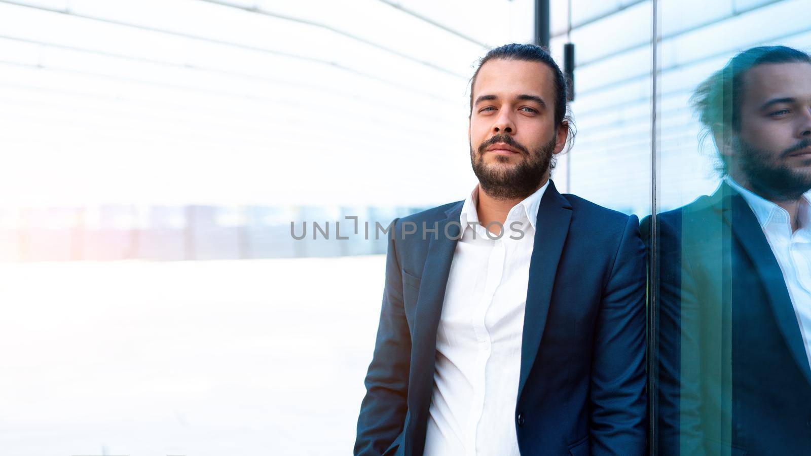 Successful businessman in suit with beard standing near office building confidently looking at camera lean wall. Hispanic male business person portrait. Web banner, Free space. Modern Business people