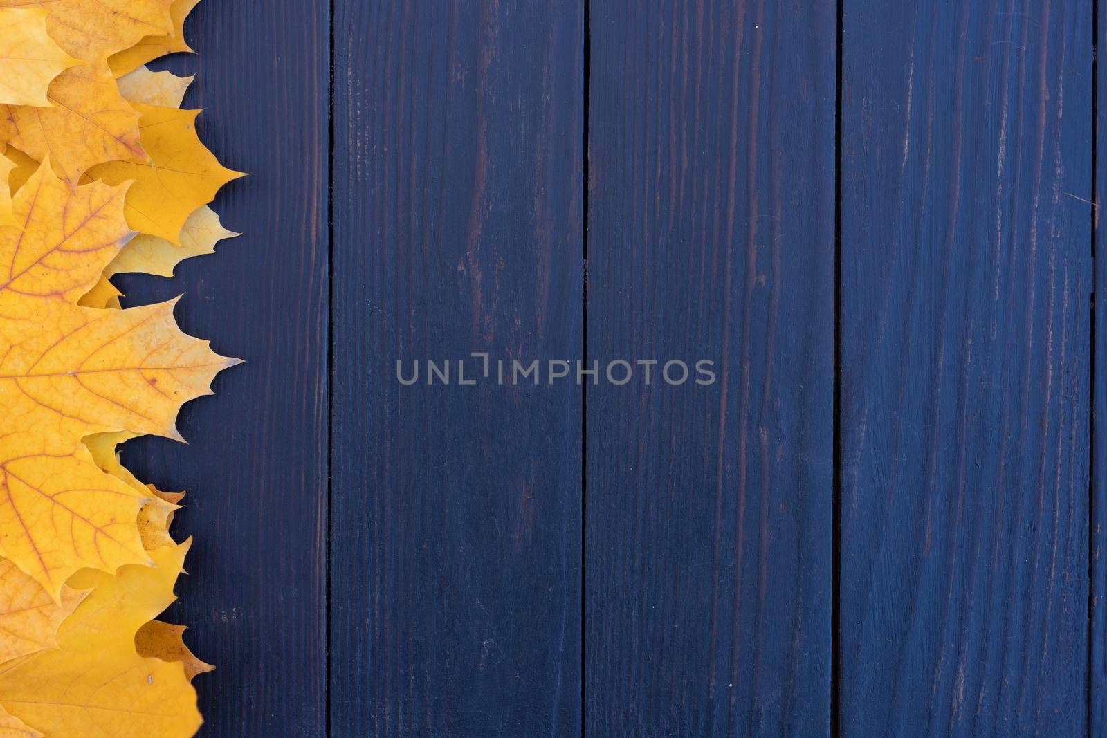 Autumn leaves frame on one left side wooden background top view Fall Border yellow and Orange Leaves vintage wood table Copy space. Mock up for your design. Display for product or text