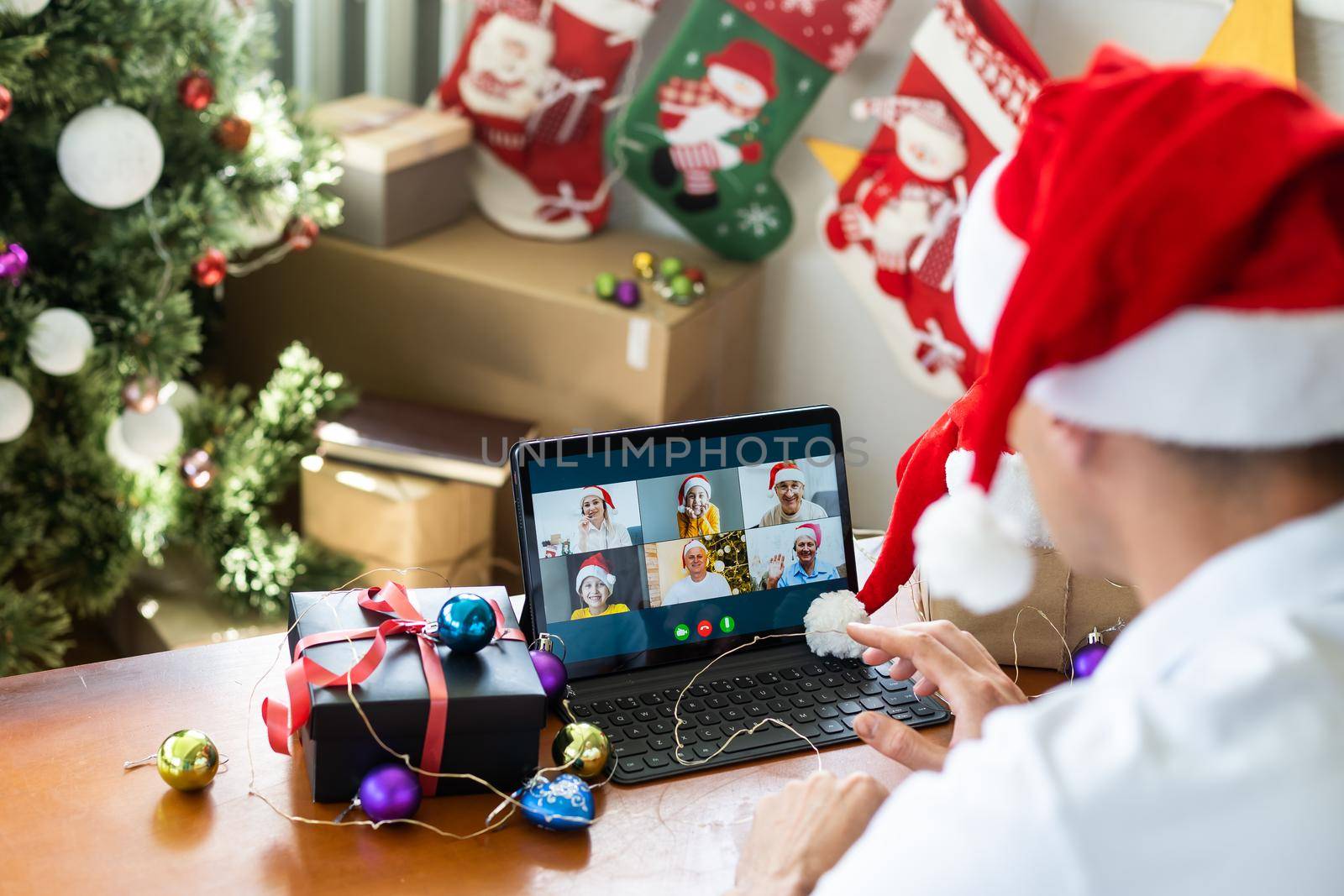 man at home christmas with santa claus hat with tablet.