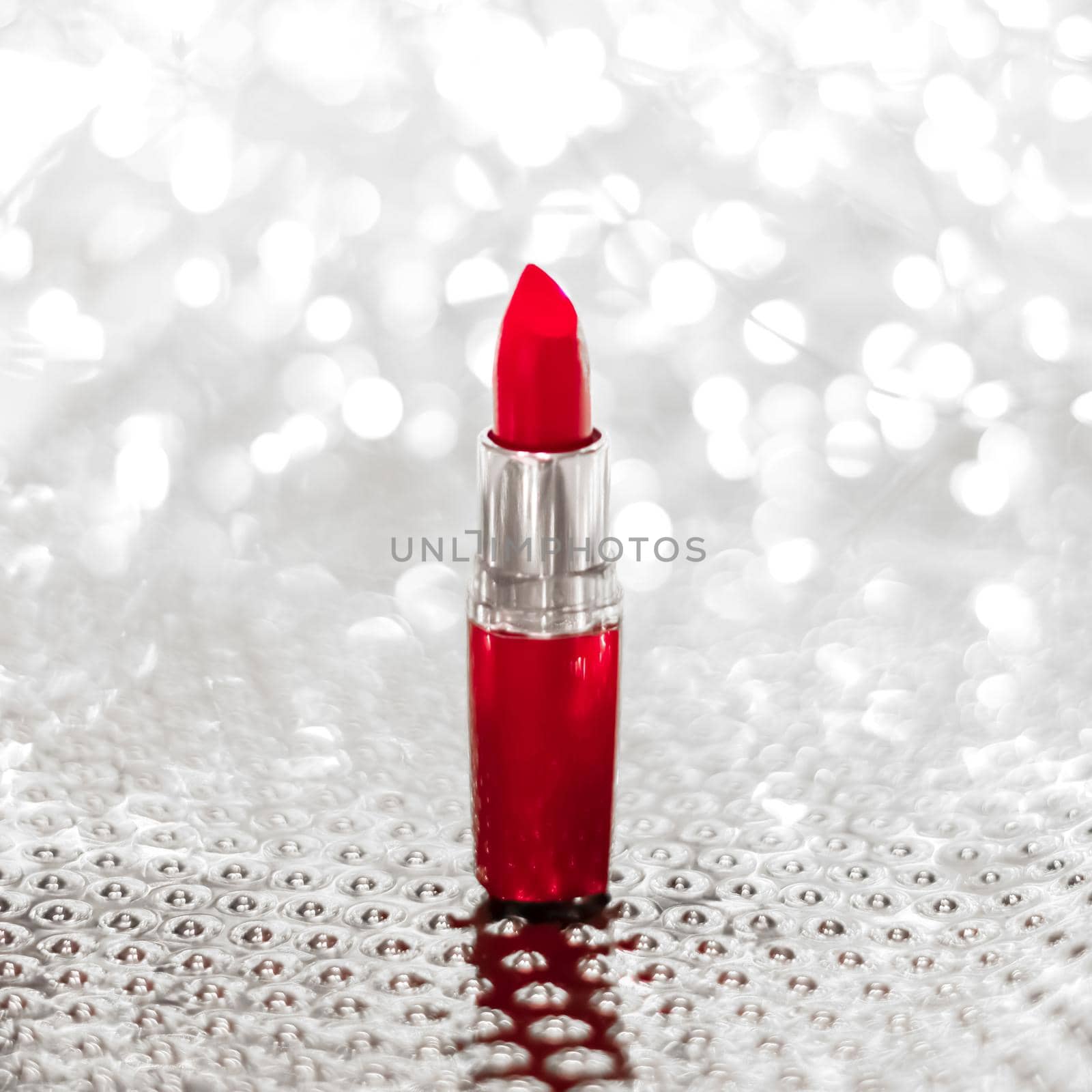 Cosmetic branding, sale and glamour concept - Red lipstick on silver Christmas, New Years and Valentines Day holiday glitter background, make-up and cosmetics product for luxury beauty brand
